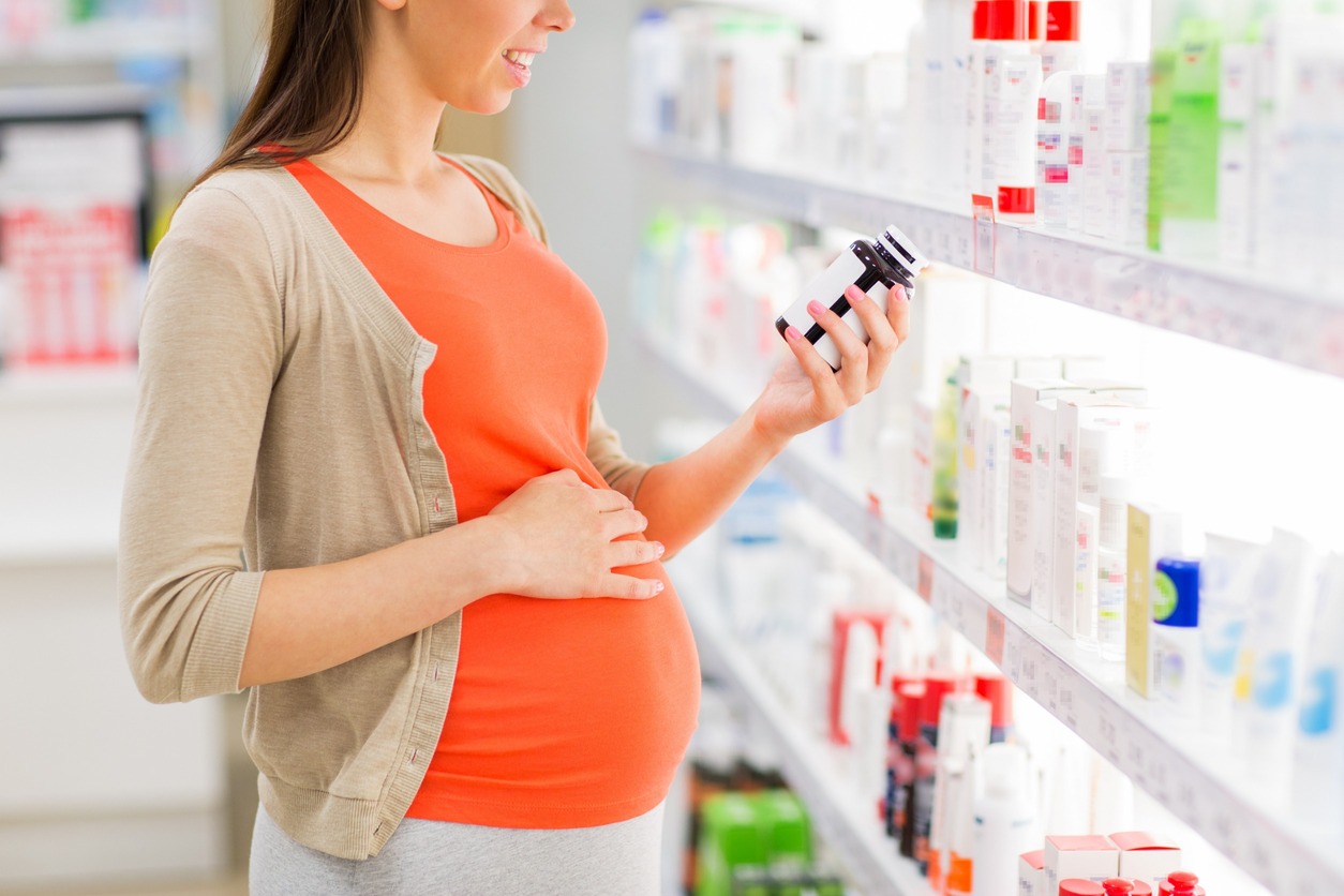 Embarazada buscando un medicamento en farmacia